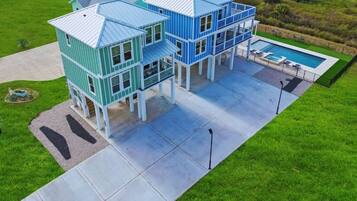 A green house with a pool and a tennis court.