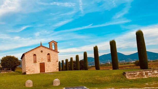A stone church with a bell tower, surrounded by neatly trimmed hedges and a grassy field. - Chalet 'Casa Dell'uliveto' with Mountain View, Wi-Fi and Air Conditioning (Albettone)