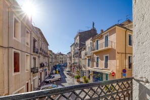 Une rue étroite, bordée de bâtiments des deux côtés, un fourgon blanc garé à gauche et un panneau « accès interdit » à droite.