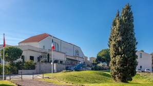 A building with a sign 'Cooperative Vincolo' and a flagpole with a flag. - Chalet 'Joli En Bois' with Private Terrace, Wi-Fi & Air Conditioning (Roquebrune-sur-Argens)