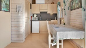 Una cocina compacta con refrigerador, microondas y lavamanos.