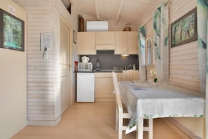 A compact kitchen with a refrigerator, microwave, and sink. - Chalet 'Superbe' with Private Terrace, Wi-Fi, and Air Conditioning (Roquebrune-sur-Argens)