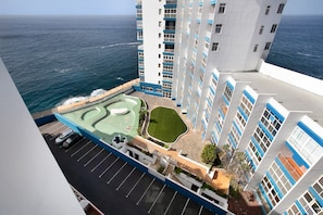 Un hôtel de grande hauteur doté d’une piscine sur le toit, d’un parking et offrant une vue sur l’océan.