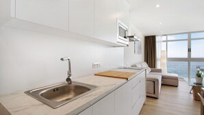 A modern kitchen with a built-in sink, a wooden countertop, and a view of the sea through large windows. - Holiday Apartment 'Luxury Loft El Roque 1' with Sea View and Wi-Fi (Tacoronte)