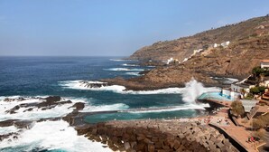 A coastal view with rocky terrain, a swimming pool, and buildings on a hillside. - Holiday Apartment 'Luxury Loft El Roque 1' with Sea View and Wi-Fi (Tacoronte)