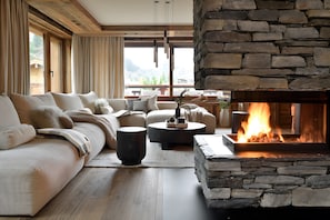 A cozy living room with a stone fireplace, a large sofa, and a coffee table.