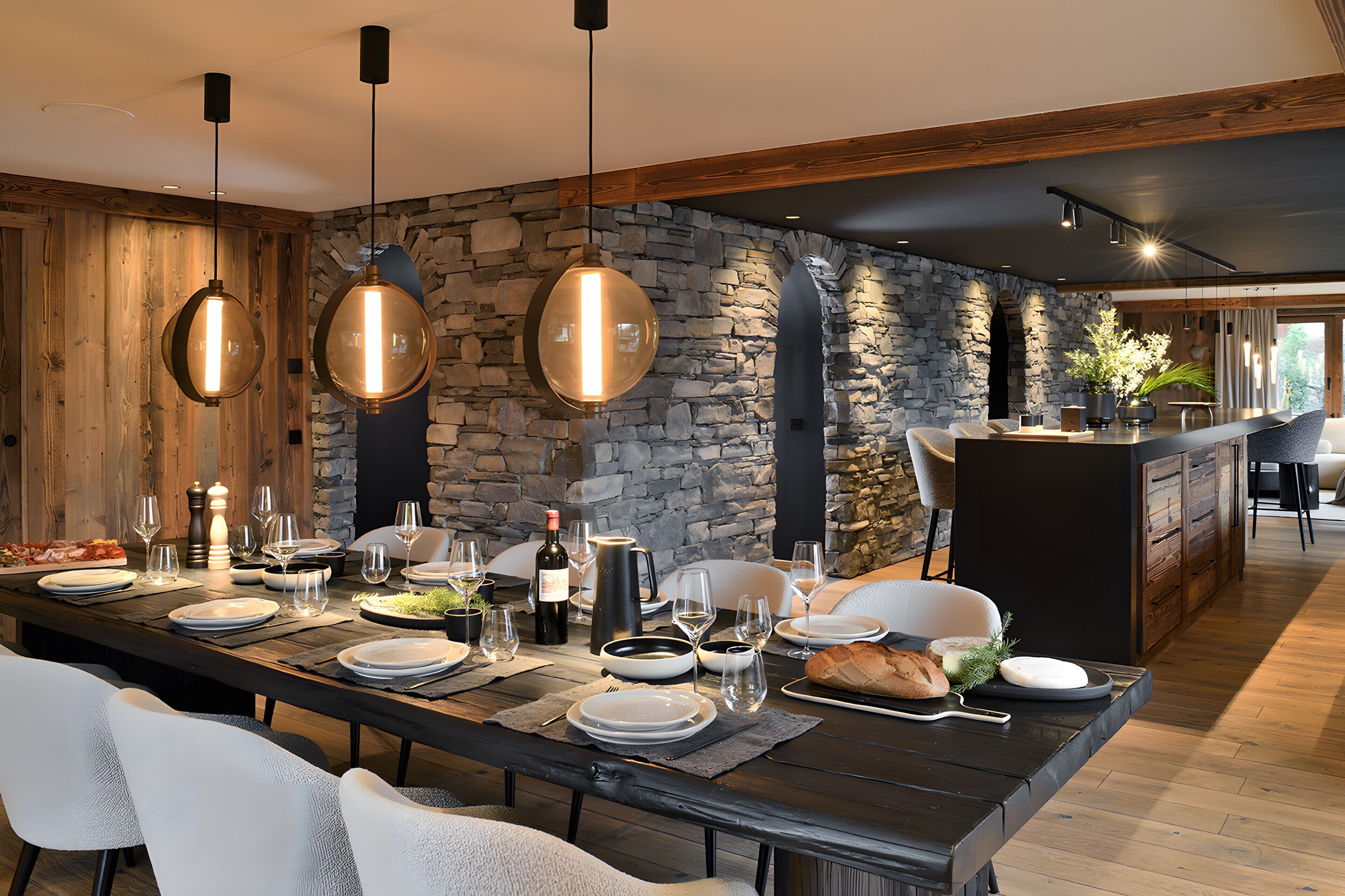A dining area with a long table set for a meal, stone walls, wooden beams, and hanging pendant lights.