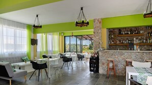 A dining area with a bar, green walls, and a stone accent wall. - Bed and Breakfast 'Ilios and Irene  3' with Shared Terrace, Wi-Fi and Air Conditioning (?ast??a??)