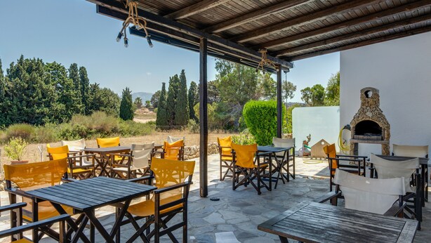 An outdoor patio with tables and chairs, a stone floor, and a stone oven. - Bed and Breakfast 'Ilios and Irene  9' with Shared Terrace, Wi-Fi and Air Conditioning (?ast??a??)