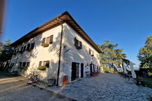 Un edificio con patio empedrado de piedra, una bicicleta y mobiliario exterior.