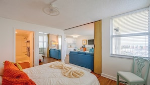 A hotel room with a bed, a chair, a kitchenette, and a bathroom. - Fort Myers Beach Studio w/ Balcony & Views! (Fort Myers Beach)