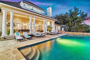 A poolside area with lounge chairs and a covered patio.