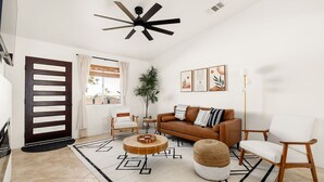A modern living room with a brown sofa, white chairs, a wooden coffee table, and a geometric patterned rug. - Modern Desert Escape - Fire Pit, BBQ and Design (Yucca Valley)