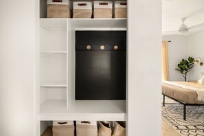 A white storage unit with multiple shelves and a black panel with three round knobs. - Modern Desert Escape - Fire Pit, BBQ and Design (Yucca Valley)