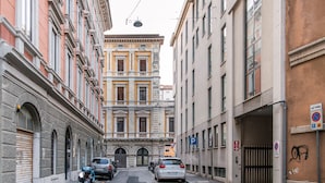 A narrow street with parked cars and motorcycles, buildings with classical architecture, and a no parking sign. - Ghiberti - Lovely Guesta Room w Bathroom (Trieste)