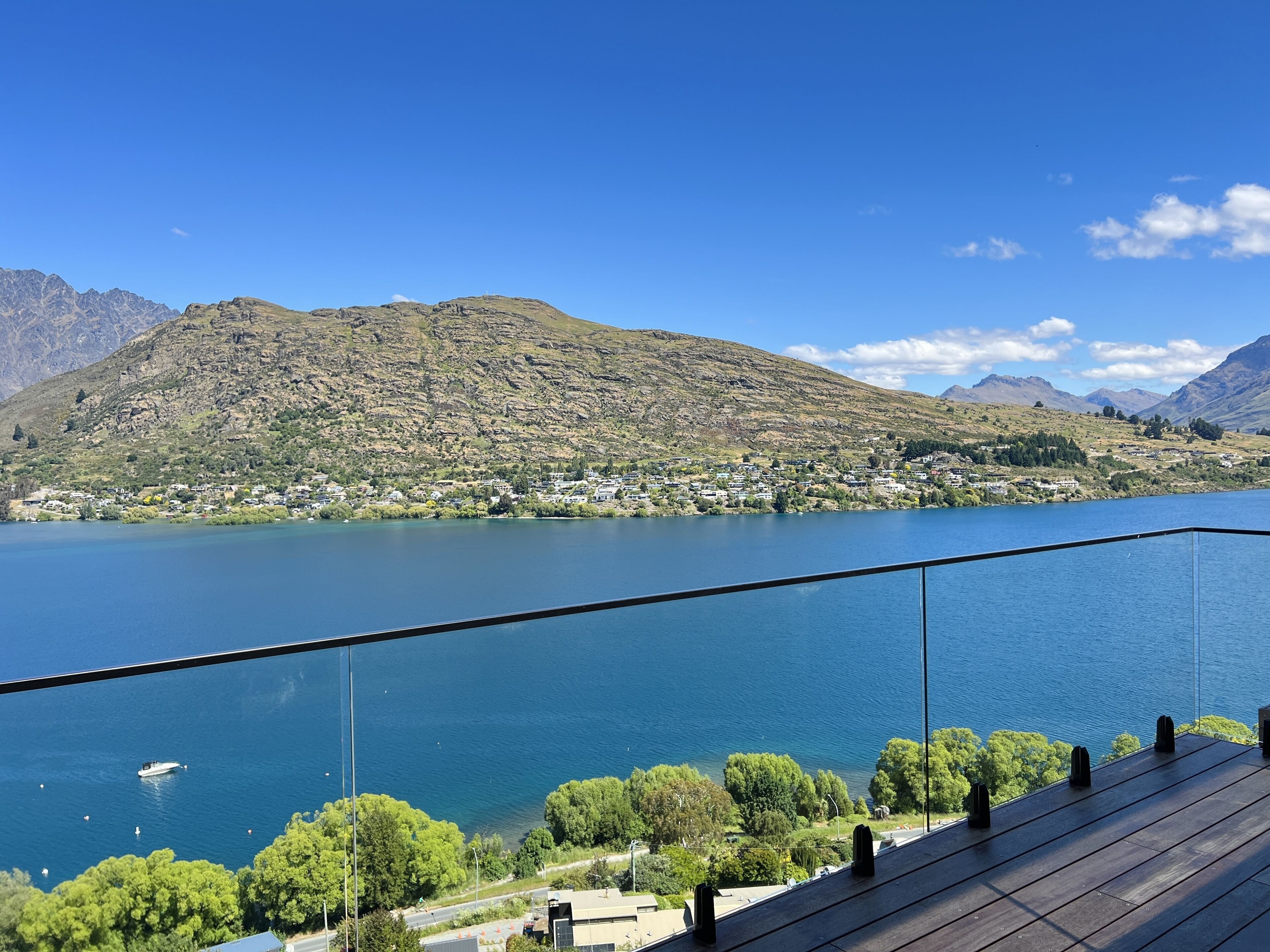 Une vue sur le lac depuis un balcon, avec les montagnes en toile de fond.