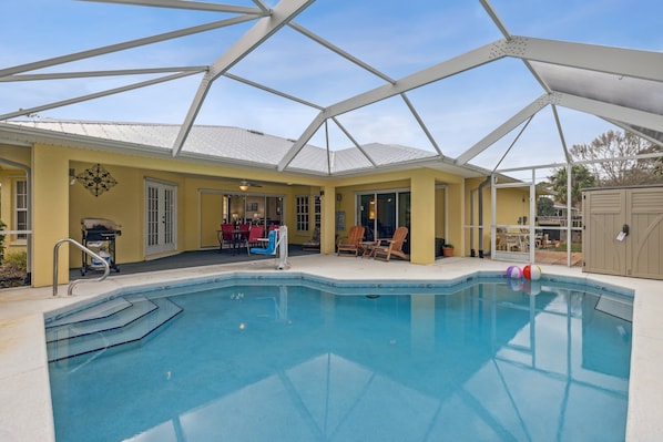 Relax by the pool surrounded by a patio with comfortable seating and a shaded area.