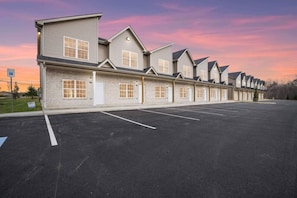 A row of single-story buildings with a parking lot in front.