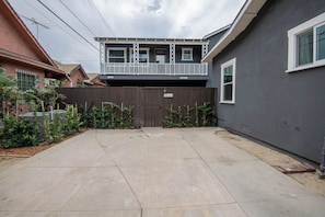A residential property with a two-story house, a fenced backyard, and a visible garage door.