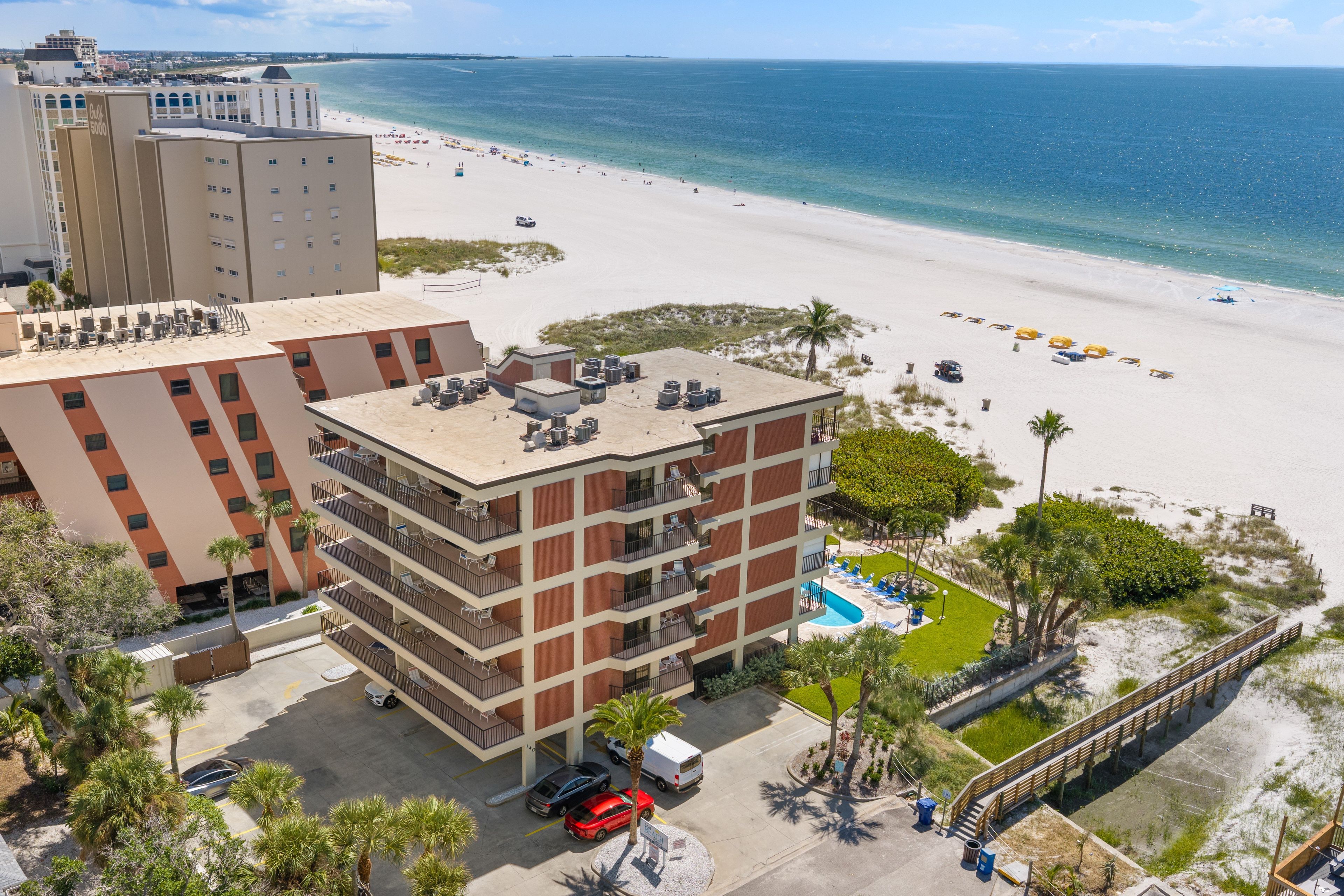 A beachfront hotel with multiple floors, a pool, and a beach view.