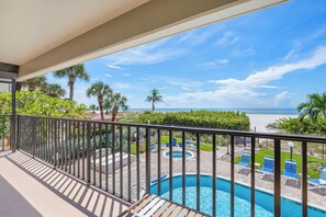 A pool area with a view of the beach and ocean. - Gulf Beach 201 - Gulf-Front Serenity with Sunset Views (St Pete Beach)