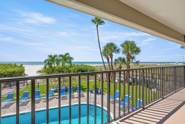 A pool area with a view of the beach and ocean.