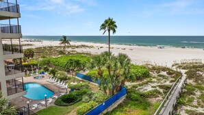 A resort with a swimming pool, beach, and ocean view.