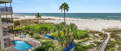 A resort with a swimming pool, beach, and ocean view.