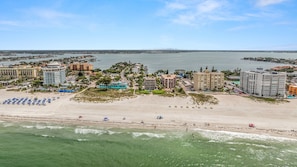 A coastal hotel area with beachfront access, multiple buildings, and a clear view of the sea.