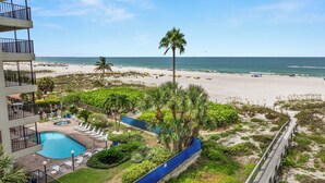 A resort with a swimming pool, beach, and ocean view.