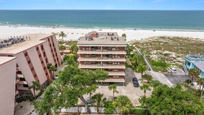 A hotel with multiple floors, outdoor seating, and a view of the beach.