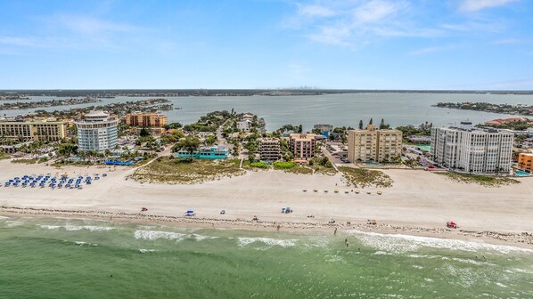 A coastal hotel area with beachfront access, multiple buildings, and a clear view of the sea.