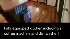 A fully equipped kitchen with a coffee machine and dishwasher.