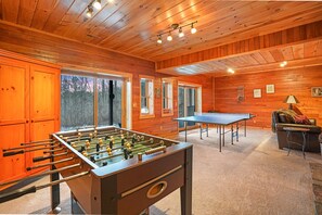Ein gemütliches Zimmer mit einem Kicker, einem Tischtennisch und einer Couch.