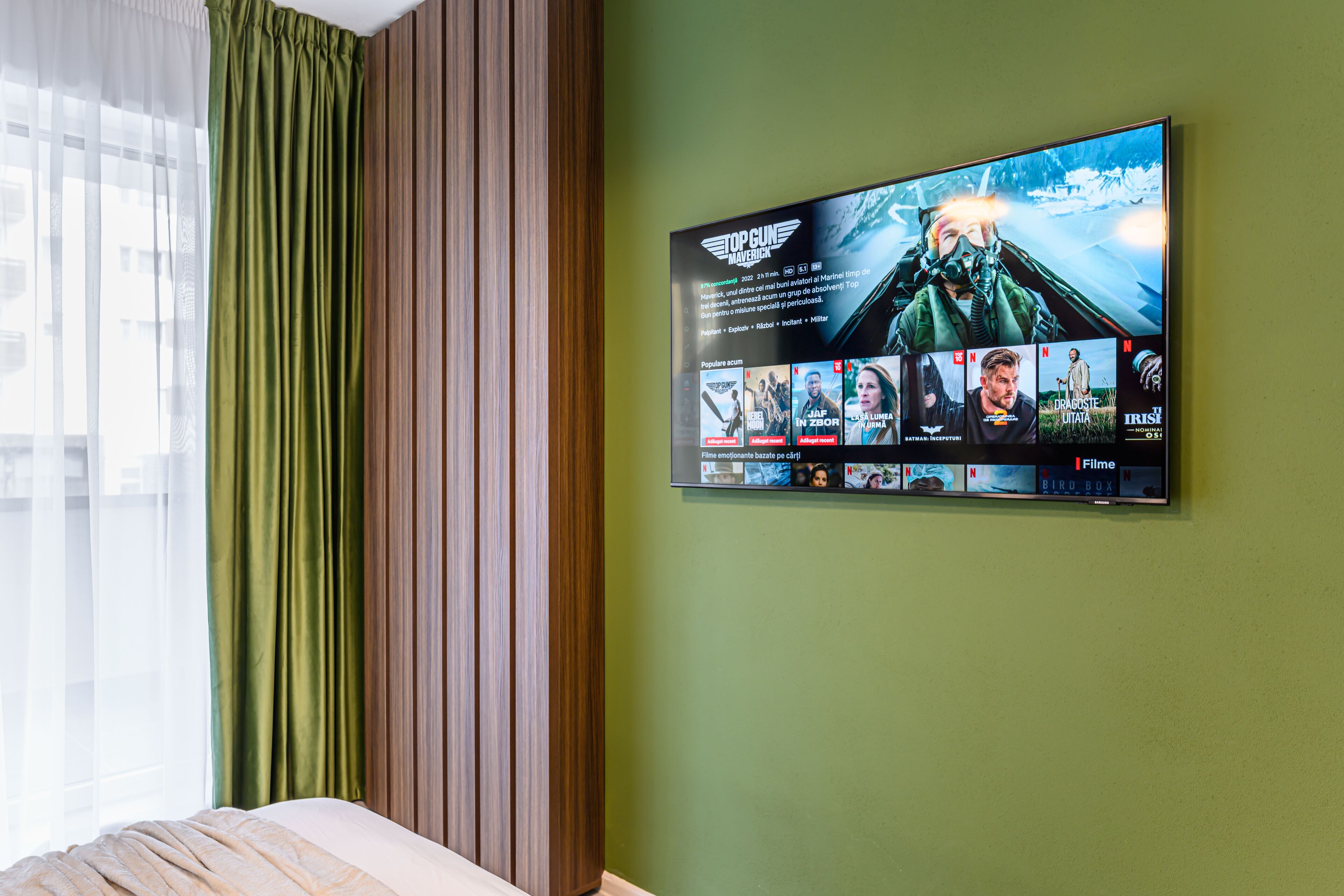 Une chambre d’hôtel dotée d’un grand téléviseur à écran plat fixé au mur, qui diffuse une sélection de films.