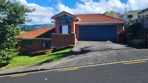 A residential house with a garage, brick exterior, and a sloped roof.
