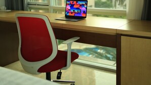 A hotel room with a wooden desk, a red chair, and a laptop. - Great location - 2BR Apartment in Senayan, Jakarta (Daerah Khusus Ibukota Jakarta)