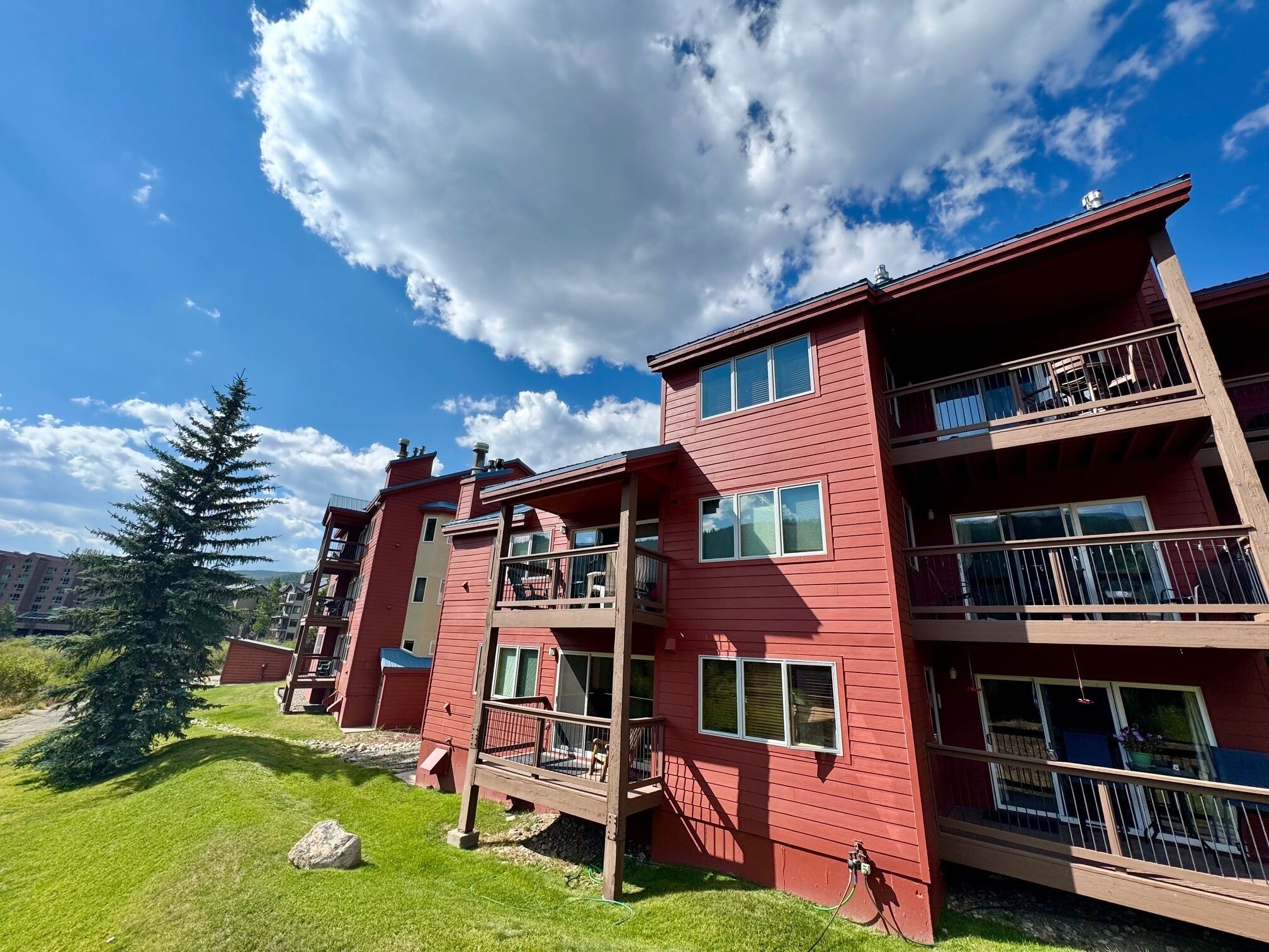 A multi-story building with balconies, large windows, and a clear sky.