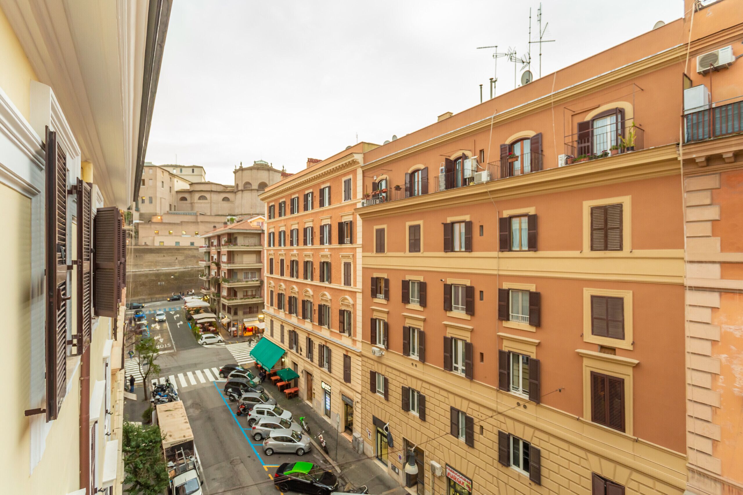 A narrow street lined with multi-story buildings, featuring balconies and a mix of architectural styles.