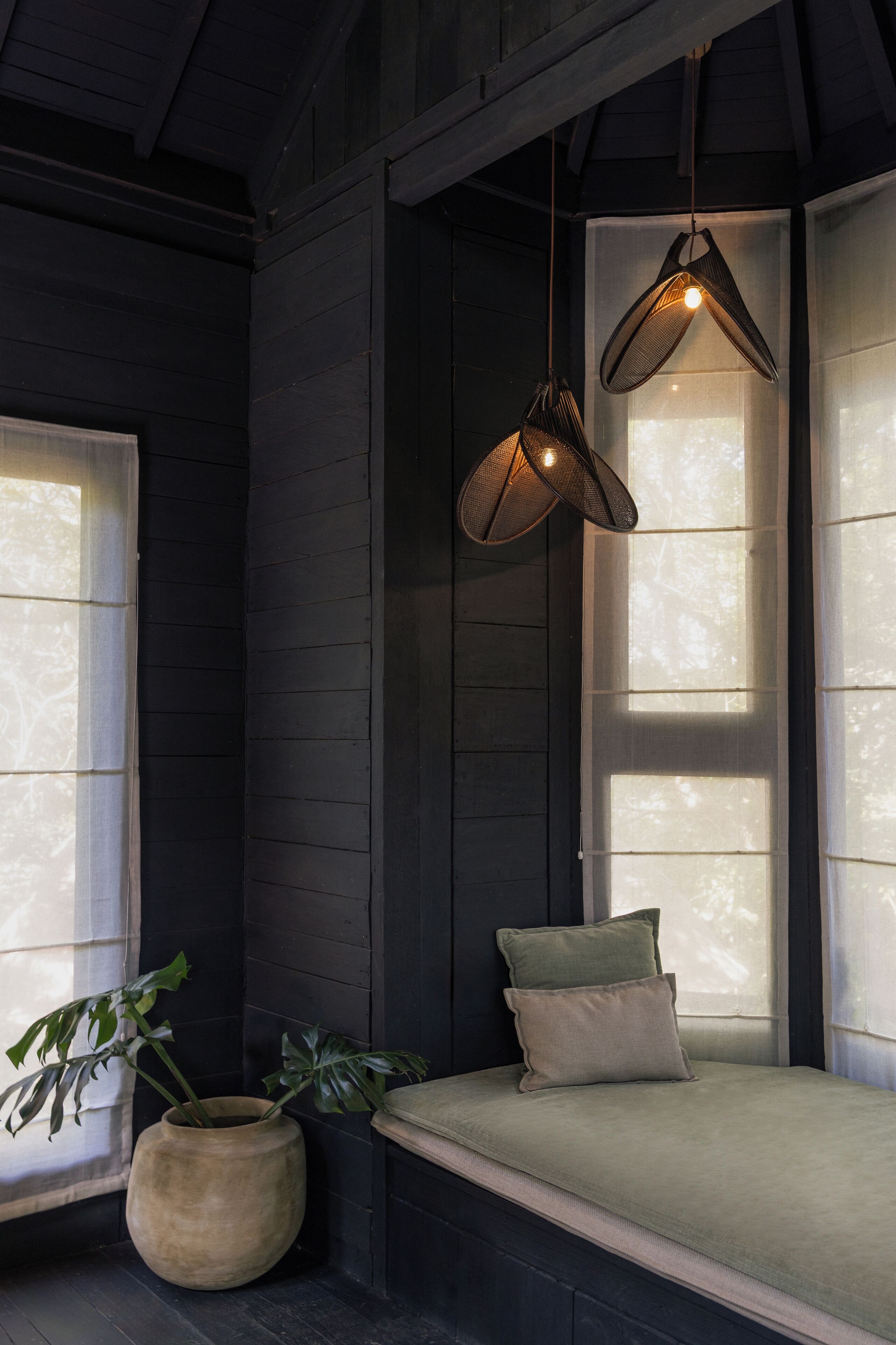 A cozy room with a built-in bench, a hanging light fixture, and a large window.