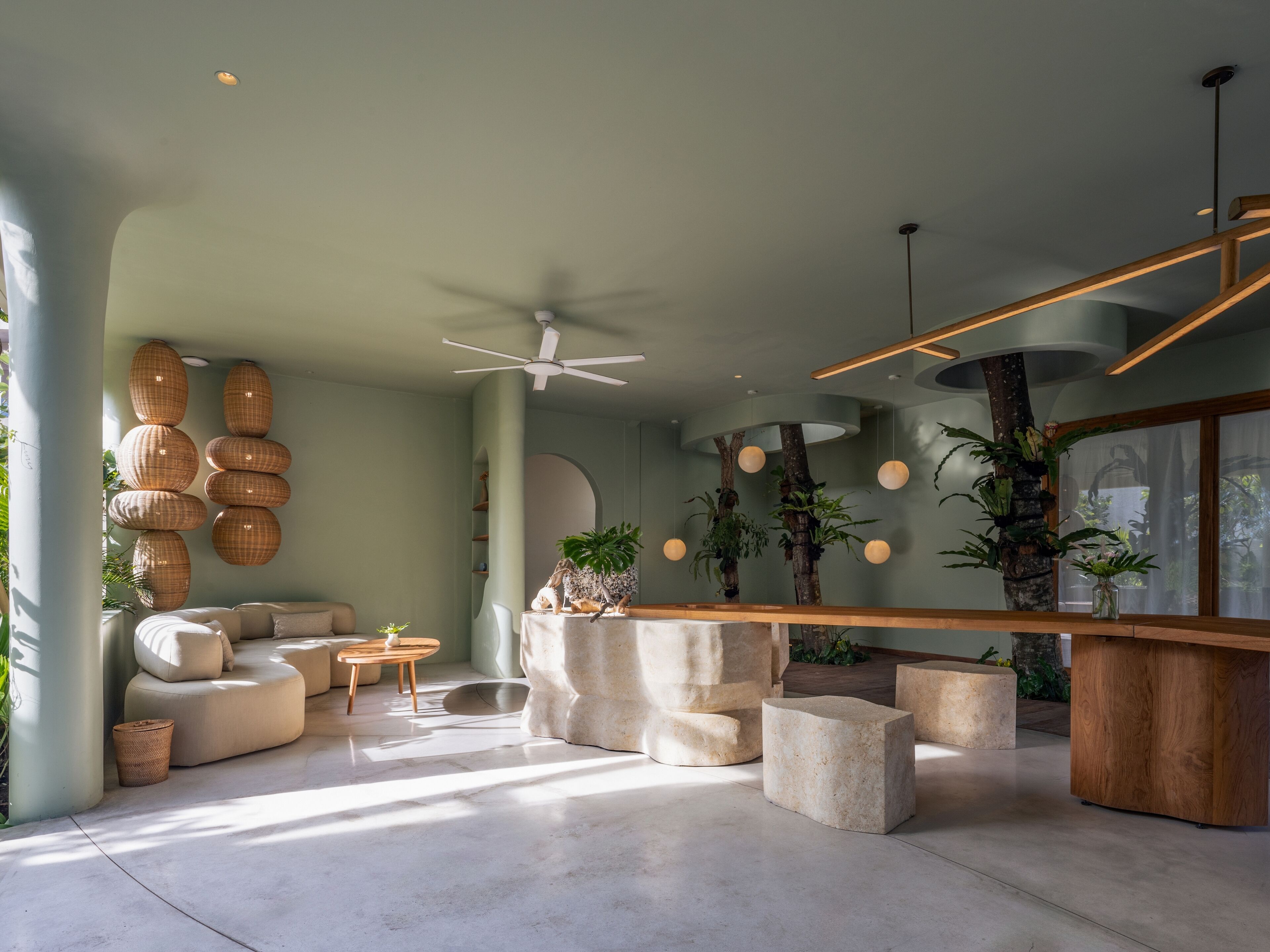 A modern living room with a sofa, a coffee table, and a stone fireplace.