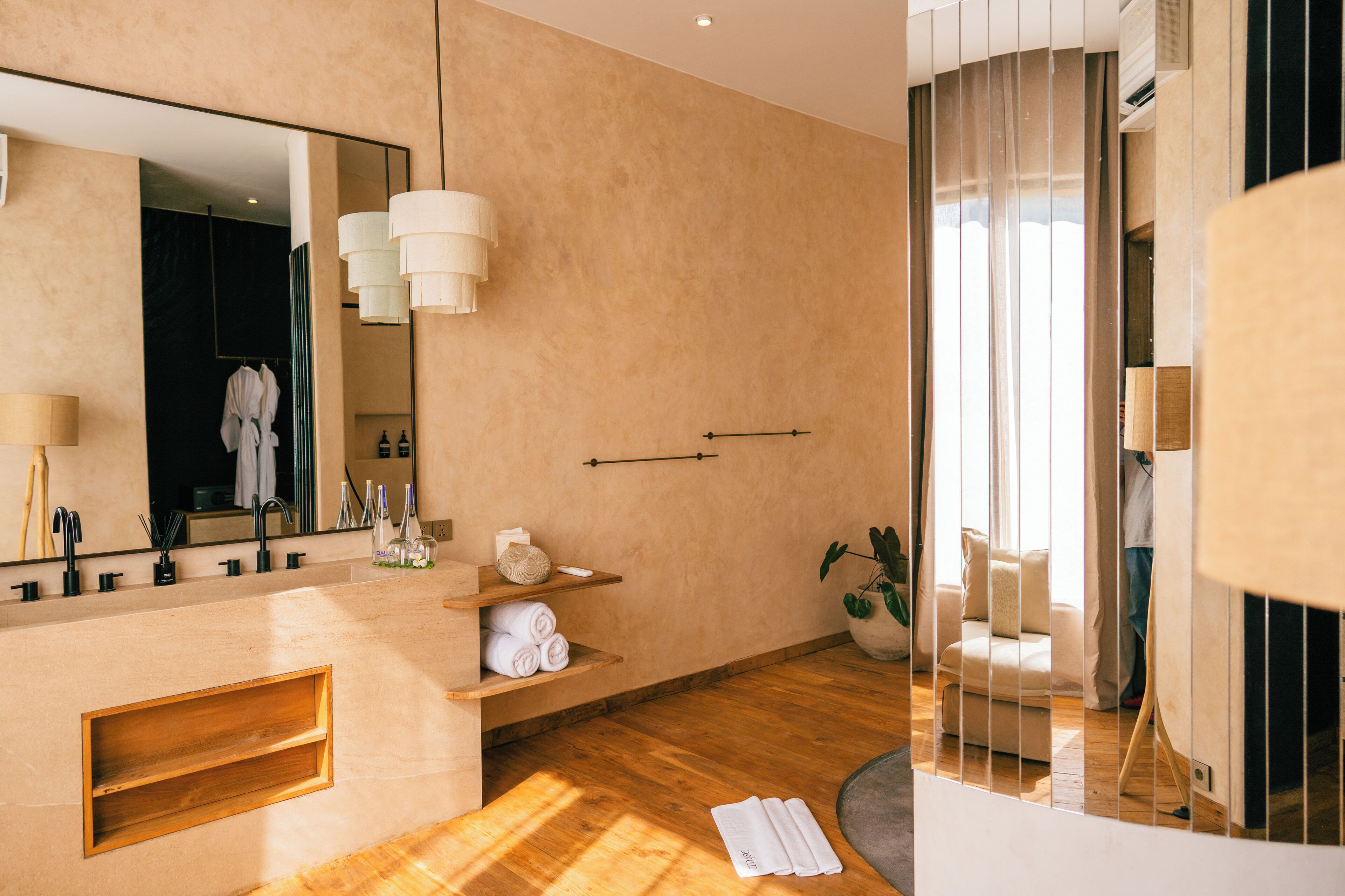 Un baño moderno con un espejo grande, tocador de madera y zona de ducha.