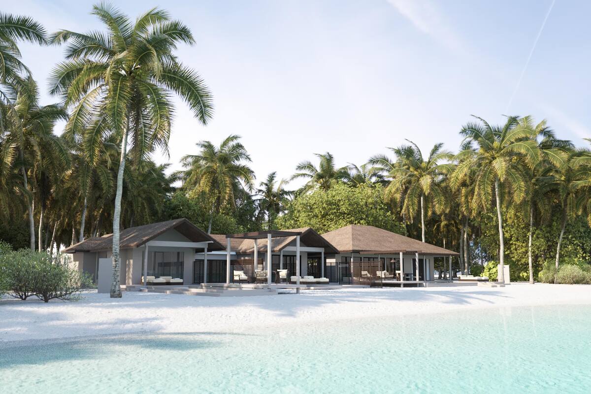 A resort with a pool, multiple buildings, and palm trees.