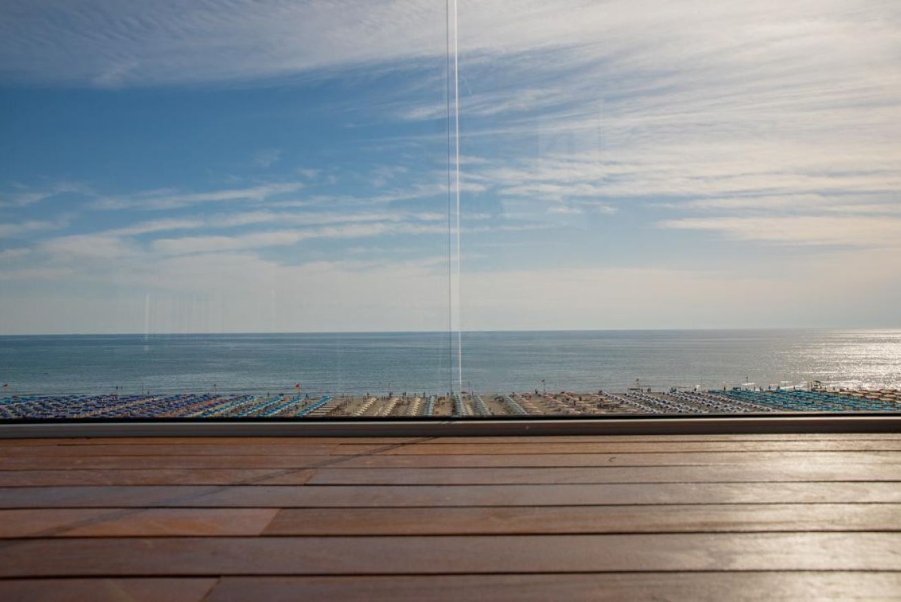 Eine Holterrasse mit Blick auf das Meer und Strandstühle.