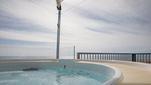 A hot tub with a view of the sea, surrounded by a deck with a railing. - Luxurious and modern penthouse facing the sea with private solarium on the seafront of Lido di Camaiore with private parking space. The flat is on two levels.The flat opens with the bright living room where there is a comfortable doublebed sofa, dining a (Lido di Camaiore)