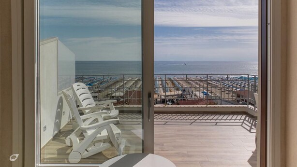 A balcony with a view of the beach and ocean. - Luxurious and modern penthouse facing the sea with private solarium on the seafront of Lido di Camaiore with private parking space. The flat is on two levels.The flat opens with the bright living room where there is a comfortable doublebed sofa, dining a (Lido di Camaiore)