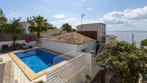 A residential property with a swimming pool, a terrace with a view of the sea, and a red umbrella. - Villa Maria by Mallorca North Villas (Alcudia)