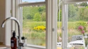 A kitchen with a view of a lake and boats.