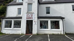 Un bâtiment blanc sur lequel on peut lire l’inscription suivante : « Harris Tweed, île de Harris ».