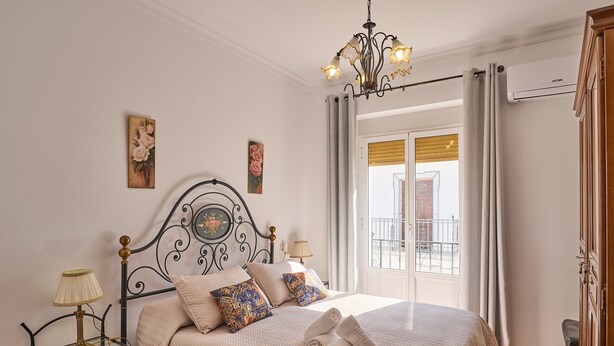 Un letto rifatto con una testata, lampade sui comodini e vista all'esterno.